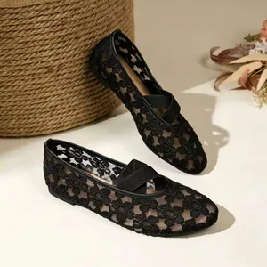 Gros plan sur des ballerines Mary Jane en maille noire avec broderies et brides
