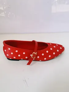 Vue latérale d'une chaussure Mary Jane rouge à pois avec boucle dorée réglable