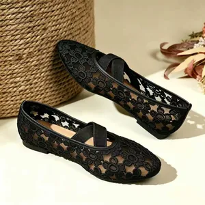 Vue détaillée des broderies florales sur les chaussures Mary Jane en résille.