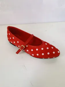 Détail de chaussures Mary Jane rouges à pois blancs avec bride et boucle dorée