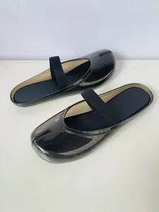Vue détaillée des sabots à bout fendu noirs avec semelle souple et sangle pour femme.