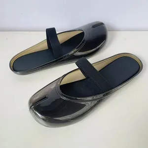 Gros plan détaillé de mules en gelée noires semi-transparentes avec bout fendu