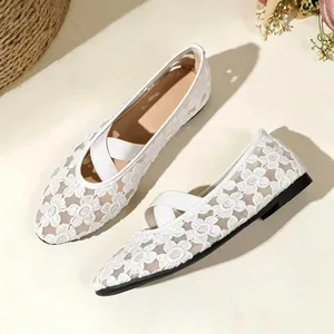 Gros plan de ballerines Mary Jane en dentelle blanche avec broderie florale et brides