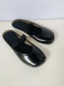 Détail de mules Tabi noires brillantes avec bride élastique et semelle souple