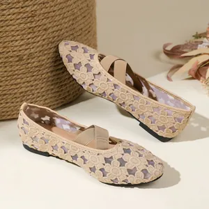Gros plan de ballerines Mary Jane en dentelle beige avec brides croisées et broderies florales