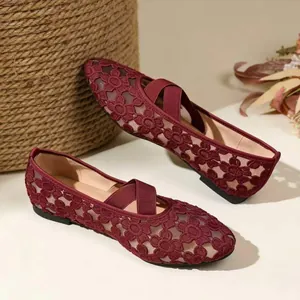 Gros plan sur la broderie florale et la texture mesh des chaussures Mary Jane rouges