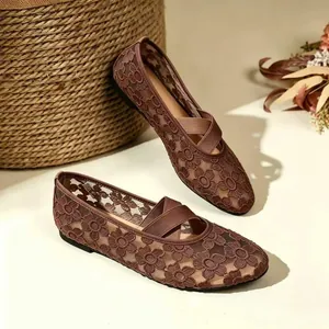 Détail des ballerines Mary Jane en dentelle marron avec broderie et brides croisées.