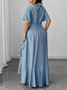 Back view of a blue polka dot plus size maxi dress with flutter sleeves and tie-waist