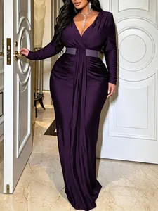 Detail of elegant deep purple V-neck long-sleeved maxi dress with cinched waist belt.