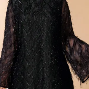 Detailed view of black fringe dress with elegant lotus leaf sleeves and silver accents.