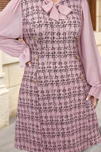 Detail view of pink tweed dress with sheer mesh sleeves and elegant bow neckline