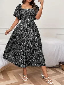 Dettaglio di un elegante abito midi nero con scollo quadrato e stampa floreale.