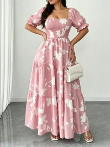 Dettaglio di un abito lungo rosa a fiori con vita arricciata e gonna a balze