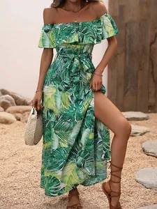 Detail of a tropical palm leaf print off-shoulder maxi dress with a high side slit