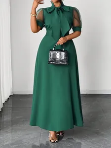 Elegant green maxi dress featuring mesh puff sleeves and a chic bow neckline detail view.