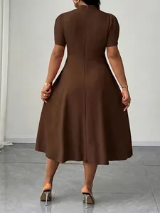 Vista posteriore di un elegante abito marrone con collo alto e maniche corte da donna