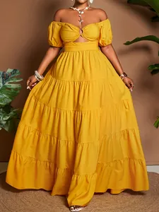 Dettaglio di un abito lungo a balze giallo senape con spalline scoperte e cut-out