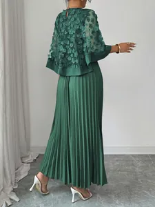 Detail van donkergroene geplooide maxi-jurk met elegante 3D-bloemen mesh cape-overlay