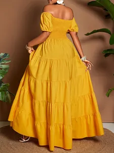 Elegante abito lungo giallo a balze con spalle scoperte e bustino elasticizzato.