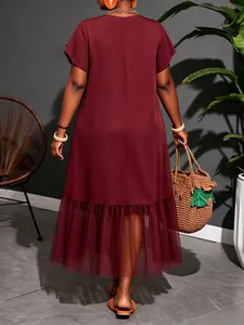 Back view of a chic plus size wine red midi dress with elegant mesh panel at the hem.