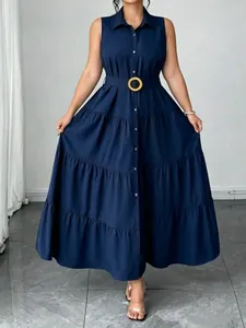Abito midi smanicato blu scuro con colletto polo, gonna a balze e cintura dorata.