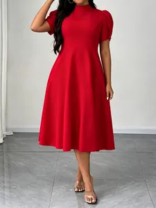 Dettaglio di un elegante abito rosso al ginocchio con colletto alto e maniche corte.