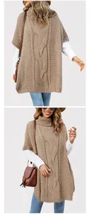 Detail view of the intricate cable-knit texture on a high-neck oversized poncho sweater