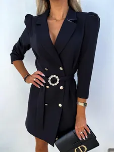 Close-up detail of navy blazer dress featuring gold buttons and a pearl buckle belt