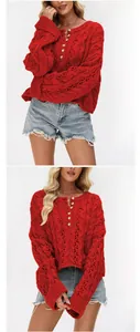 Detailed view of red cable-knit pullover featuring buttons and hollow-out texture