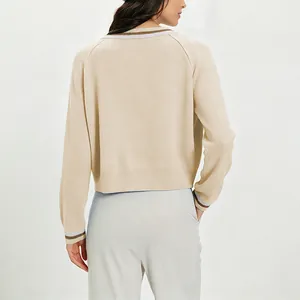 Vista trasera de una elegante chaqueta de punto beige con cuello y puños a rayas