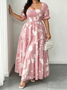 Dettaglio dell'abito lungo rosa floreale con scollo quadrato e maniche a sbuffo.