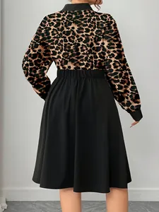 Rear view of an elegant leopard print midi dress featuring a black flared skirt design