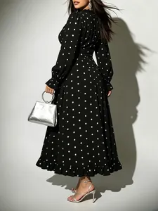 Close-up view of the back of a black and white polka dot midi dress with ruffled hem