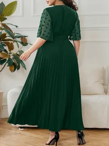 Elegant dark green pleated maxi dress back view with sheer textured sleeves.