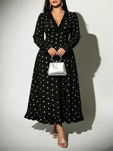Detail shot of elegant black V-neck polka dot midi dress with ruffle trim and long sleeves