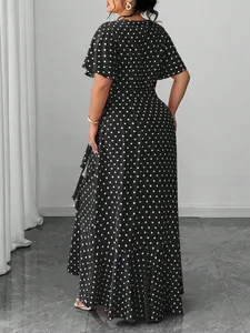 Back view of elegant plus size black and white polka dot midi dress with flutter sleeves.