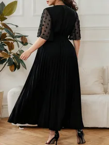 Back view of elegant plus size black pleated maxi dress with mesh polka dot sleeves
