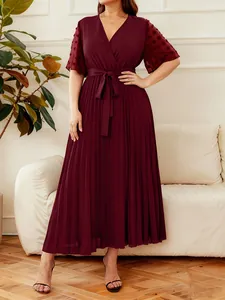 Detailed view of an elegant pleated burgundy maxi dress featuring a V-neck and waist tie