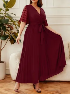 Elegant burgundy V-neck pleated maxi dress with sheer polka dot flutter sleeves and tie-waist.