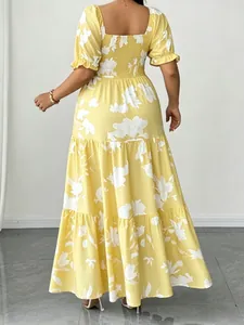 Vista posteriore di un abito lungo giallo a fiori con gonna a balze e scollo quadrato.