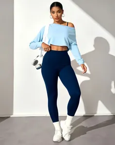 Détail d'une femme portant un haut court bleu à manches longues et un legging bleu marine