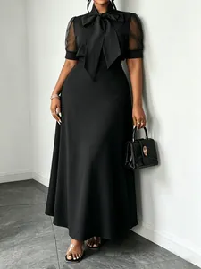Detailed view of black mesh sleeve dress with elegant butterfly bow collar