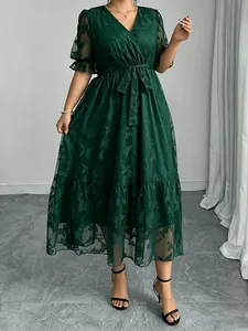 Elegantes dunkelgrünes Spitzen-Midikleid mit V-Ausschnitt und Schmetterlingsmustern.
