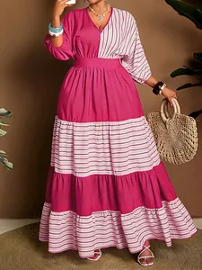 Detailed view of striped and solid pink V-neck tiered maxi dress with waist belt.