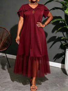 Detail view of a burgundy mid-length dress featuring a mesh hem and elegant V-neck.