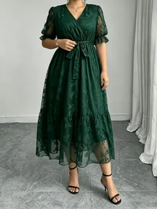 Detailansicht des eleganten dunkelgrünen Spitzenkleides mit V-Ausschnitt und Muster.