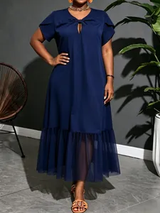 Detail view of the navy plus size midi dress featuring a mesh patchwork ruffle hem.