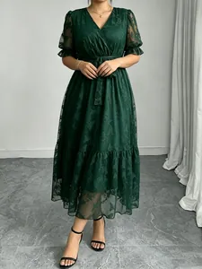 Model-Ansicht der eleganten Silhouette eines dunkelgrünen Spitzen-Midikleids mit V-Ausschnitt