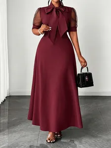 Close-up of elegant burgundy midi dress featuring mesh puff sleeves and bow-tie neck.
