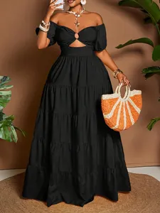 Elegante abito lungo nero con spalle scoperte, balze e dettaglio cut-out sul davanti